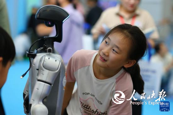 10月2日，在山东省第九届滕州书展现场，小朋友与机器人互动。     新华社发（李志军摄）