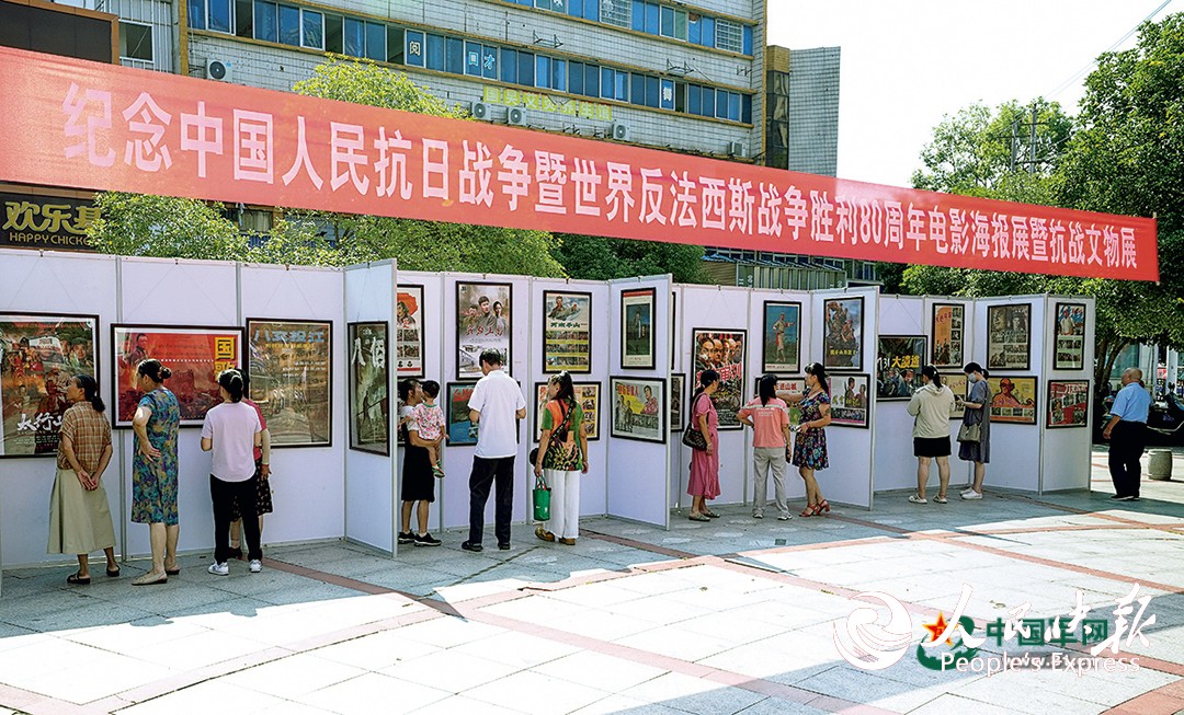 江西省上高县举办纪念中国人民抗日战争暨世界反法西斯战争胜利80周年电影海报展暨抗战文物展,市民驻足观展。邝小文摄